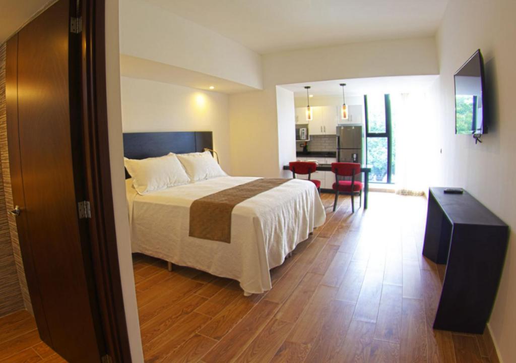 a bedroom with a bed and a kitchen with a table at Suites Terraza Imperial in Guatemala