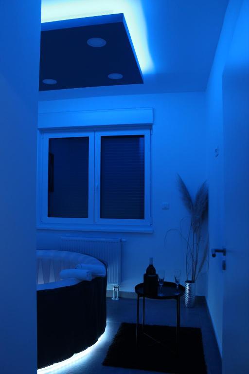niebieski pokój z łóżkiem i stołem w obiekcie Jacuzzi Apartment Code 96 w Zagrzebiu
