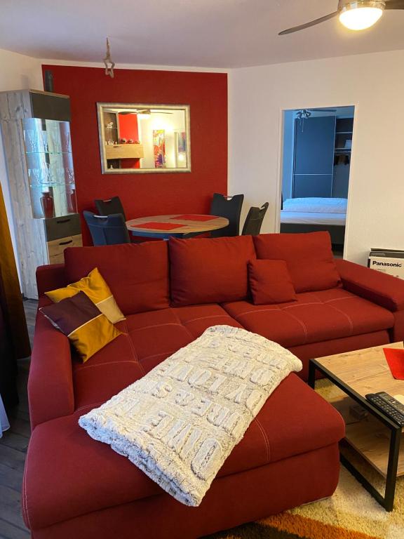 uma sala de estar com um sofá vermelho e uma mesa em Ferienwohnung Artemis em Hanôver