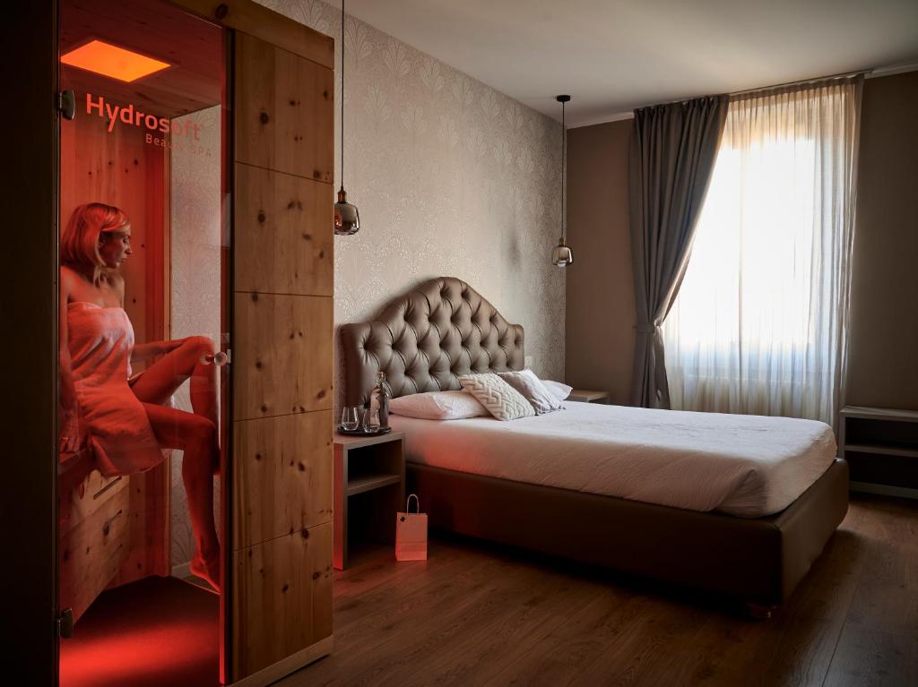 a hotel room with a bed and a mirror at Lainez Rooms & Suites in Trento