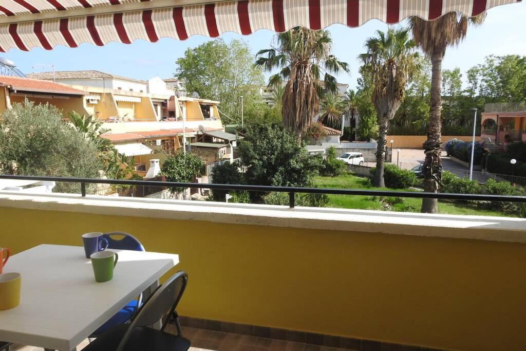 a balcony with a table and chairs and palm trees at Capitana Home in Santa Luria