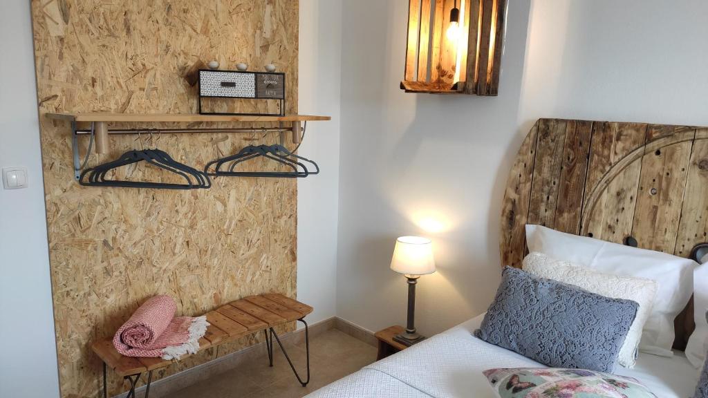 - une chambre avec un lit et une tête de lit en bois dans l'établissement Casa D Amélia, à Óbidos
