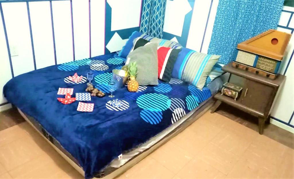 een bed met een blauw dekbed met ananas erop bij Cuarto entrada independiente privado solo para ti narvarte roma valle cerca Hospitales Centro Médico SXXI y Macgregor Regional IMSS 1 Parque Delta Narvarte WTC in Mexico-Stad