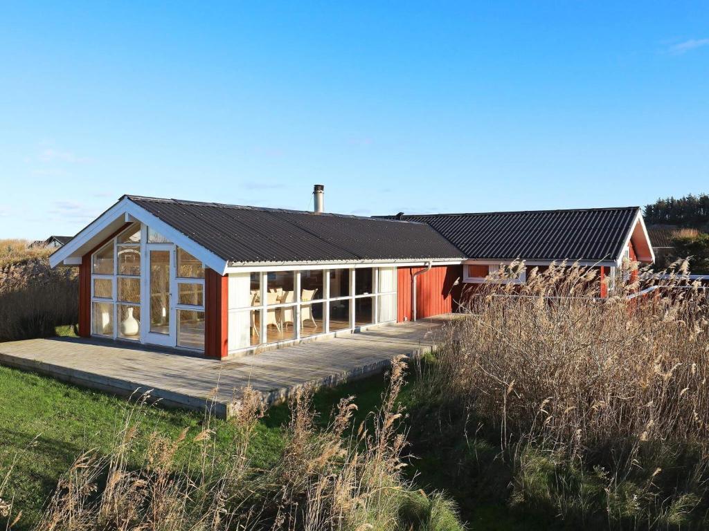 czerwono-biały dom z tarasem w obiekcie 6 person holiday home in Hj rring w mieście Sønderlev