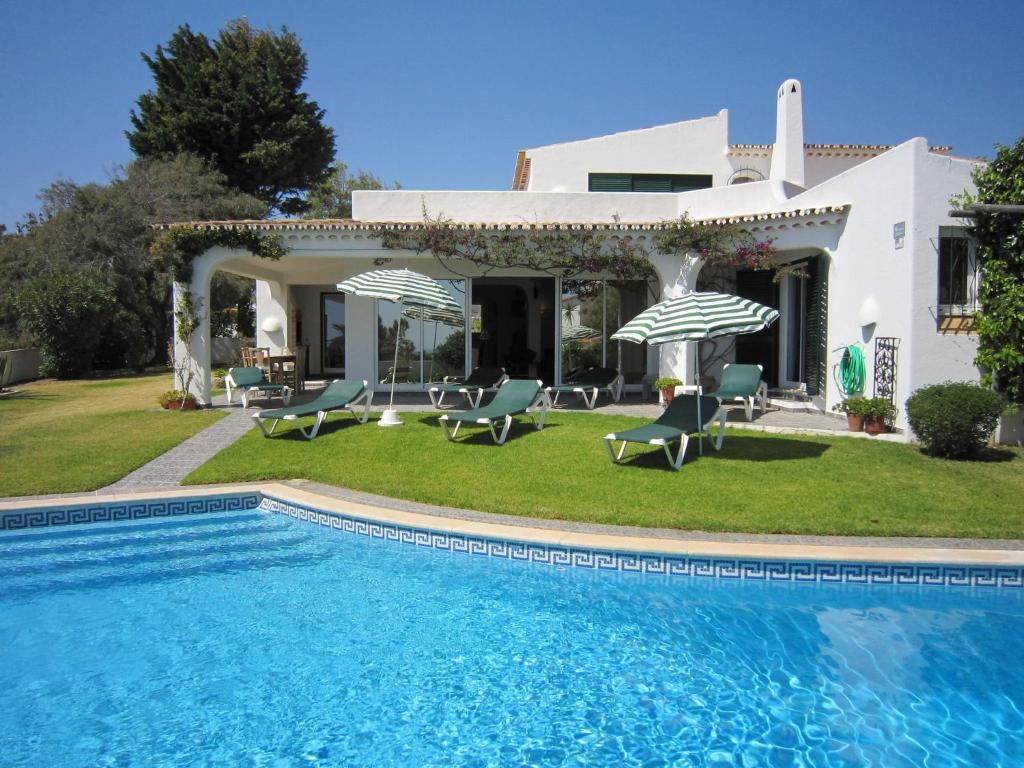 a villa with a swimming pool in front of a house at Fantastic Villa in Albufeira with Private Swimming Pool in Albufeira
