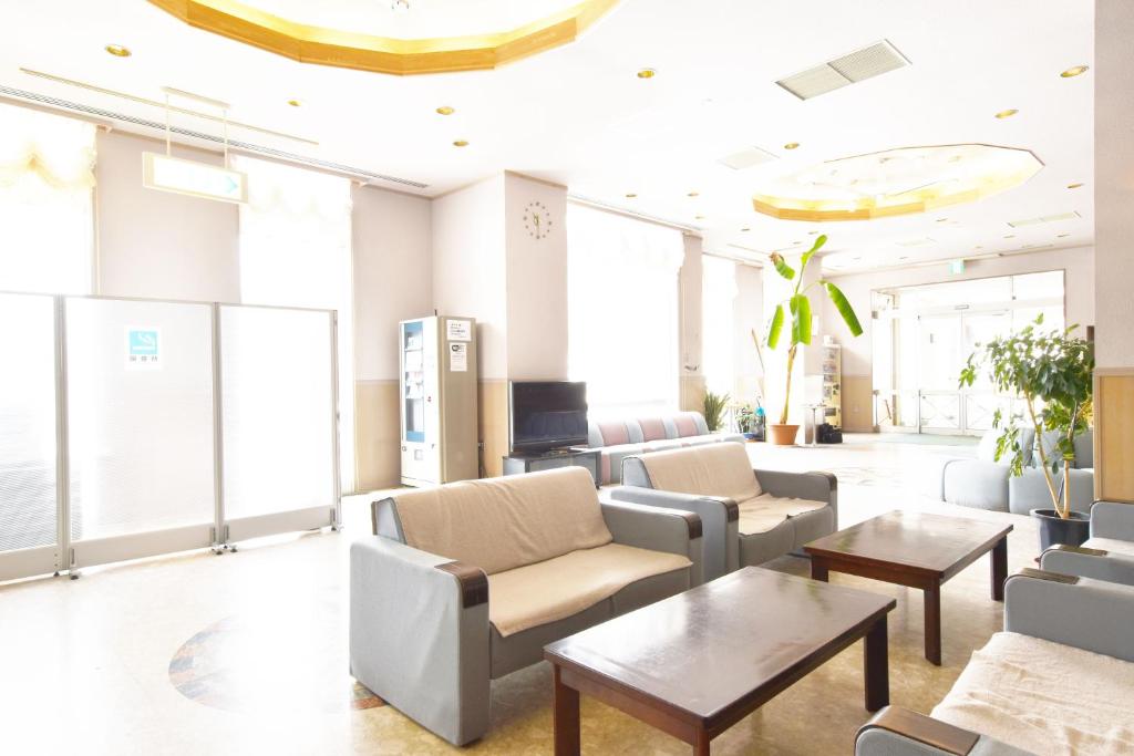 a waiting room with couches and tables and windows at Nayoro Onsen Sunpillar in Nayoro