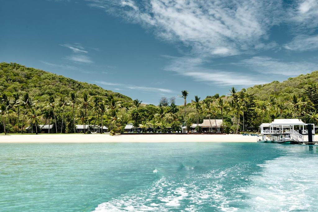 a view of a beach with a boat in the water at Orpheus Island Lodge in Orpheus Island