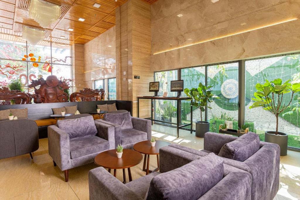 A bright hotel lounge with upholstered sofas, armchairs and small tables.