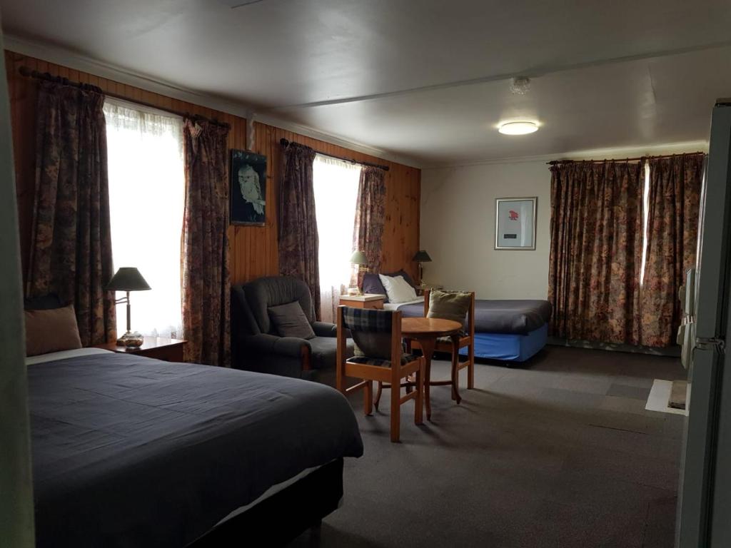 Clunes的住宿－克倫斯汽車旅館，酒店客房带一张床、一张桌子和椅子