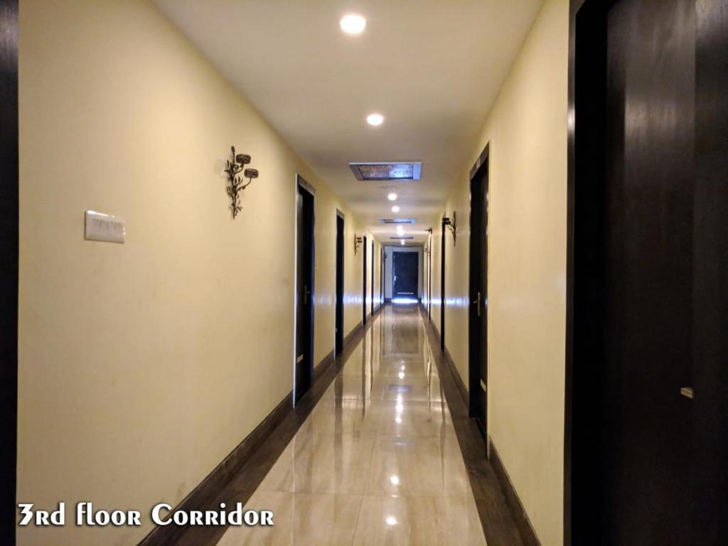 un pasillo con un largo pasillo con puertas y suelos en Hotel Madhuvan by TravelkartOnline, en Dhanbād