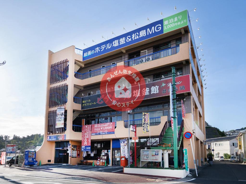 un edificio con letreros al lado de una calle en Ｔａｂｉｓｔ ホテル塩釜&松島 en Shiogama