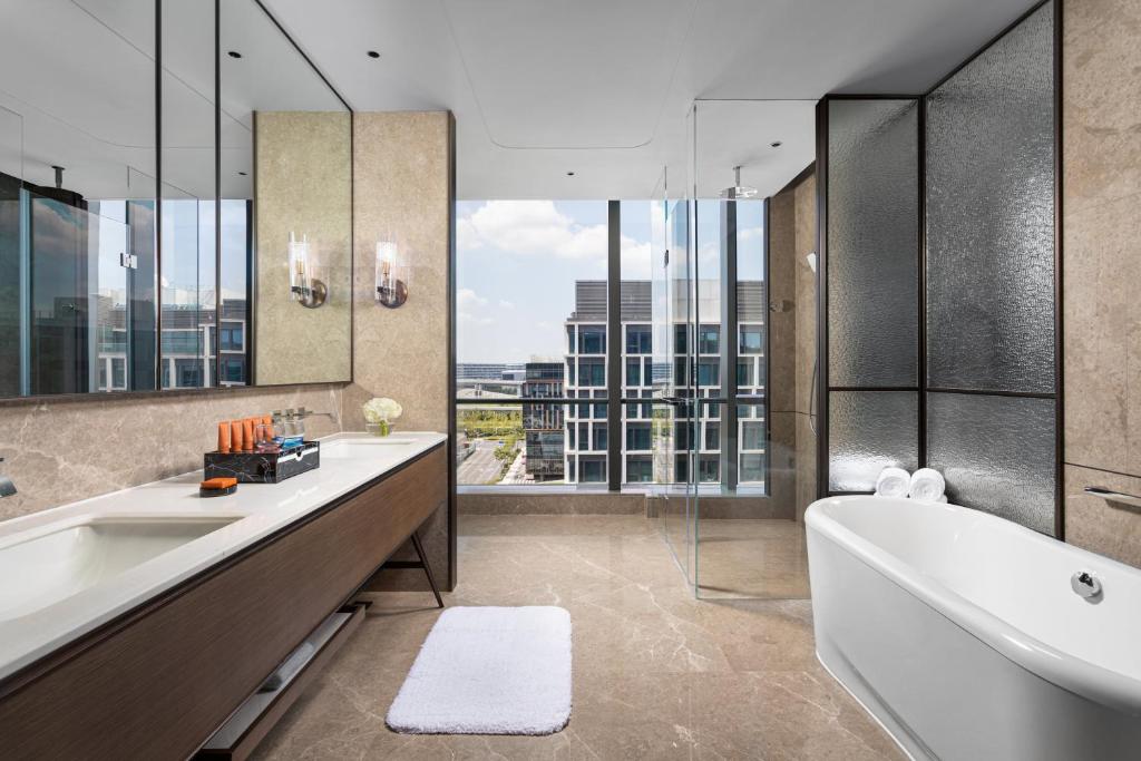 a bathroom with two sinks and a tub and a large window at Crowne Plaza Shanghai Hongqiao by IHG in Shanghai