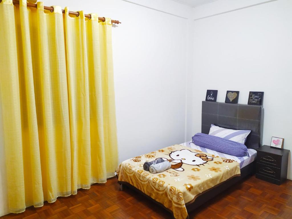 een slaapkamer met een bed met gele gordijnen bij Victoria Homestay Sibu - Next to Shopping Complex, Party Event & Large Car Park Area with Autogate in Sibu