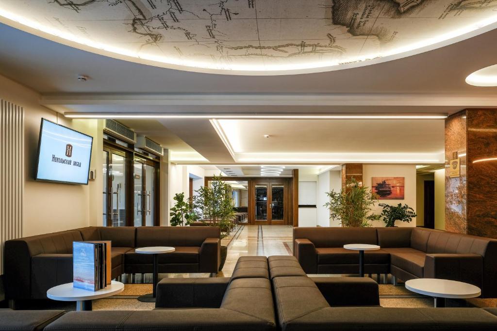 セヴェロドヴィンスクにあるHotel Nikolsky Posadの建物内のロビー(ソファ、テーブル付)