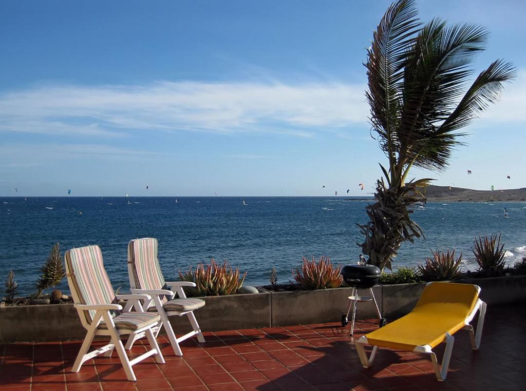 two chairs and a table on a patio overlooking the ocean at BARLOVENTO by RENTMEDANO Luxury beach front apartment with fantastic ocean views in El Médano