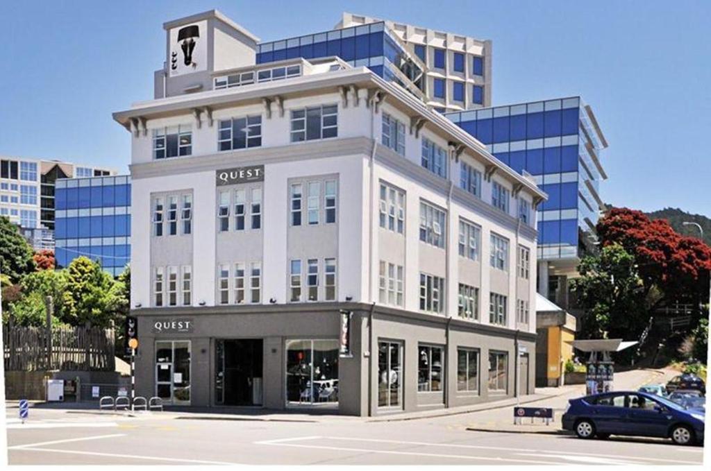 a large white building with a car parked in front of it at Quest on Thorndon in Wellington