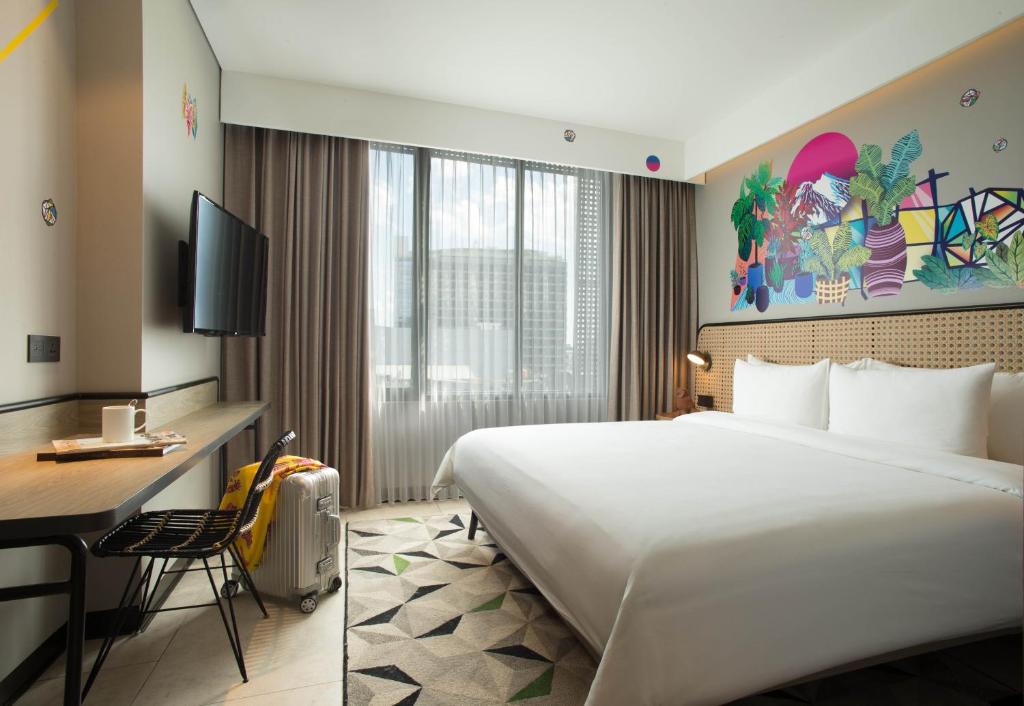 Postel nebo postele na pokoji v ubytování ARTOTEL Yogyakarta