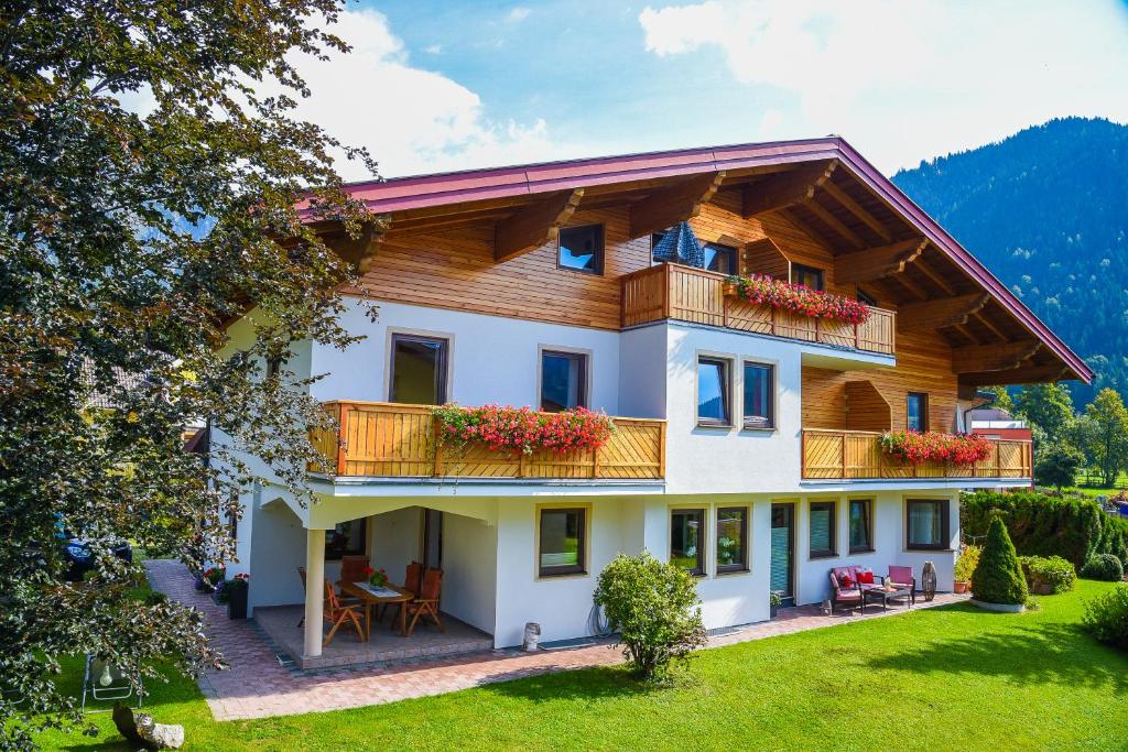 ein Haus mit einem Balkon mit Blumen darauf in der Unterkunft Haus Alpenflora in Werfenweng