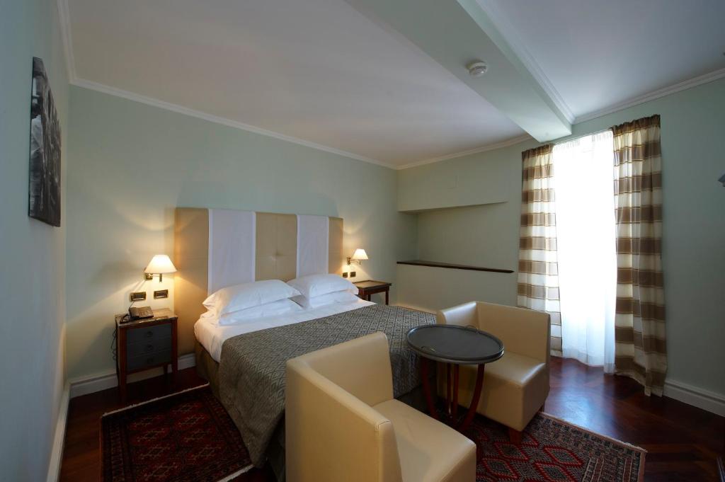 Postel nebo postele na pokoji v ubytování Grand Hotel Piazza Borsa