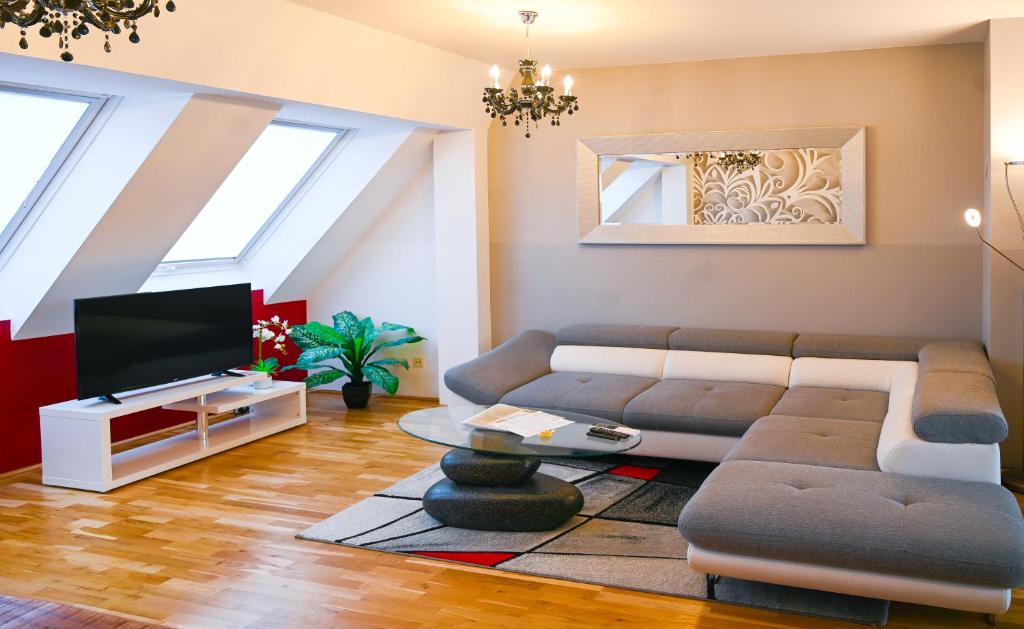 ein Wohnzimmer mit einem Sofa und einem TV in der Unterkunft Royal Residence Leopoldstadt in Wien