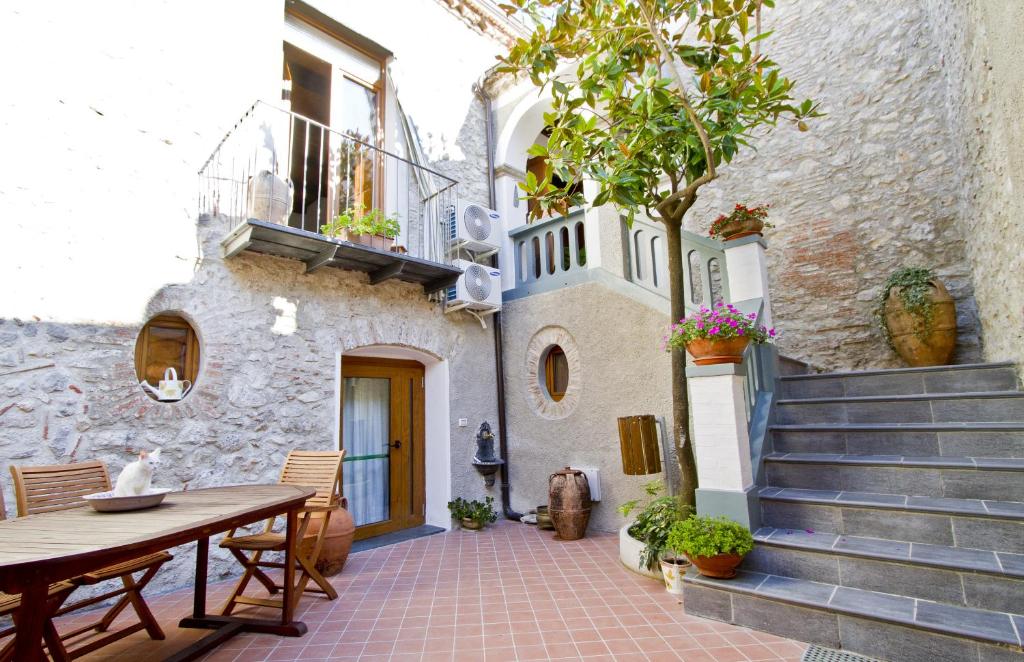 un patio con una mesa de madera y una casa en Ospitalità Don Carlo, en Tortorella