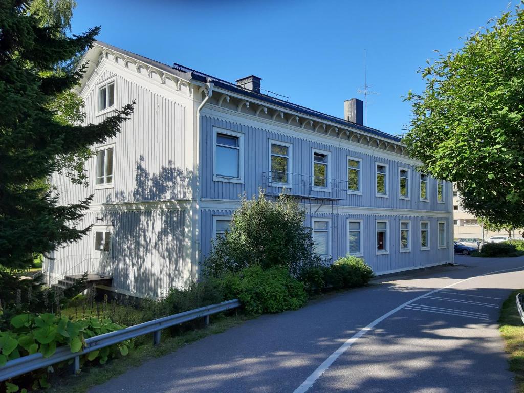 a blue and white building with a road at Piteå Vandrarhem in Piteå