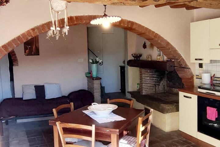 a kitchen and dining room with a table and a living room at Appartamento rustico con vista in Montelupo Fiorentino