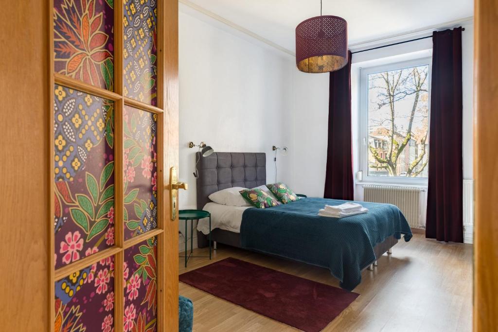 una camera con letto e finestra di Travel Homes - The Wooden, Spacieux & bon quartier a Mulhouse
