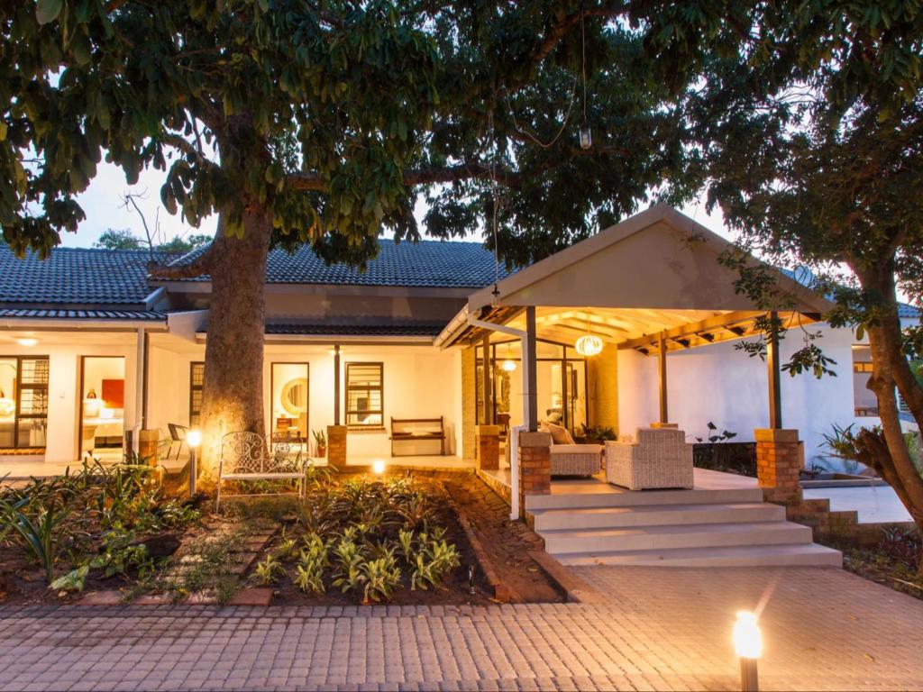 a home with a patio and a tree at The Coral Tree in Nelspruit