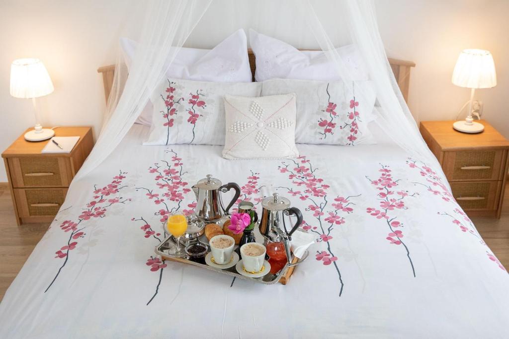 a tray of food on a bed with flowers at Apartament Na Wierchu in Murzasichle