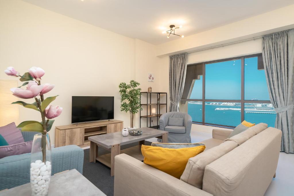 a living room with a couch and a tv at HiGuests - Fantastic Sea Views Apt in JBR by the Beach in Dubai