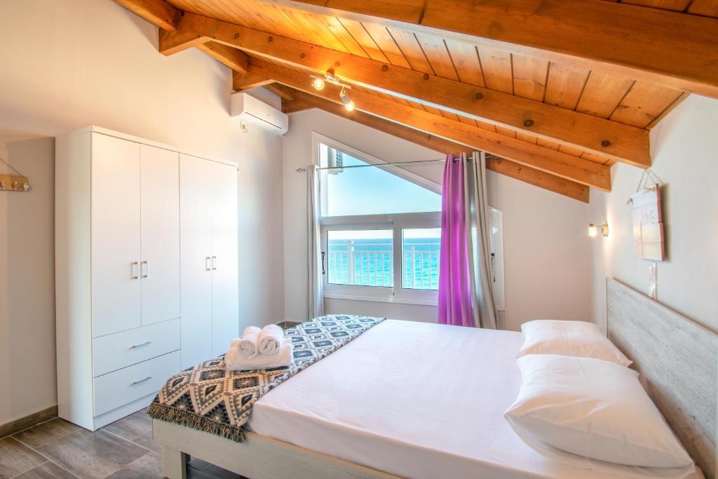 a bedroom with a large bed and a window at Amore Del Mare in Amoudi