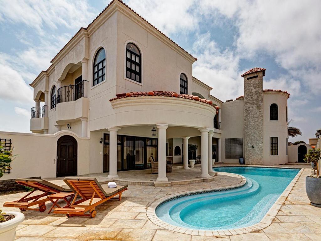 a large house with a swimming pool in front of it at Lagoon Suites Boutique Hotel in Walvis Bay