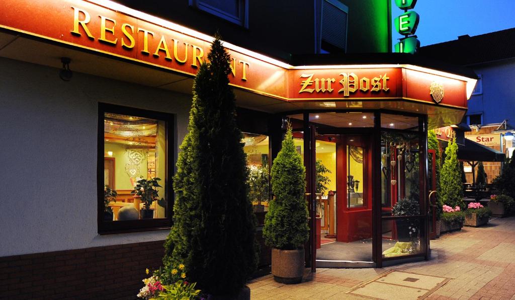 a restaurant with a sign on the side of a building at Hotel Restaurant Zur Post Lohfelden in Kassel