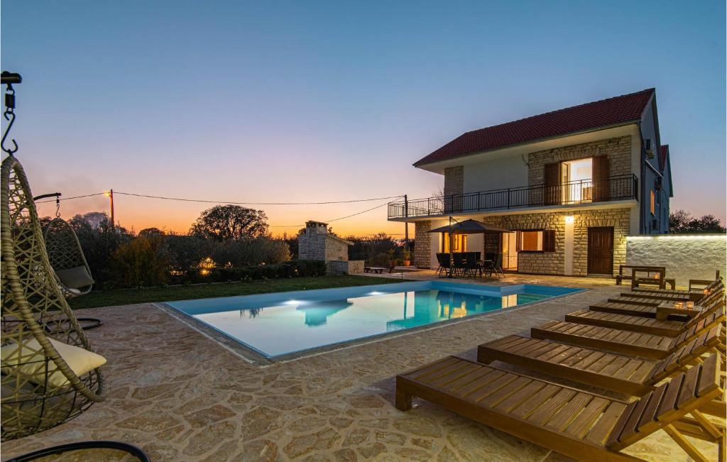 a villa with a swimming pool and a house at 4 Bedroom Awesome Home In Sibenik in Piramatovci