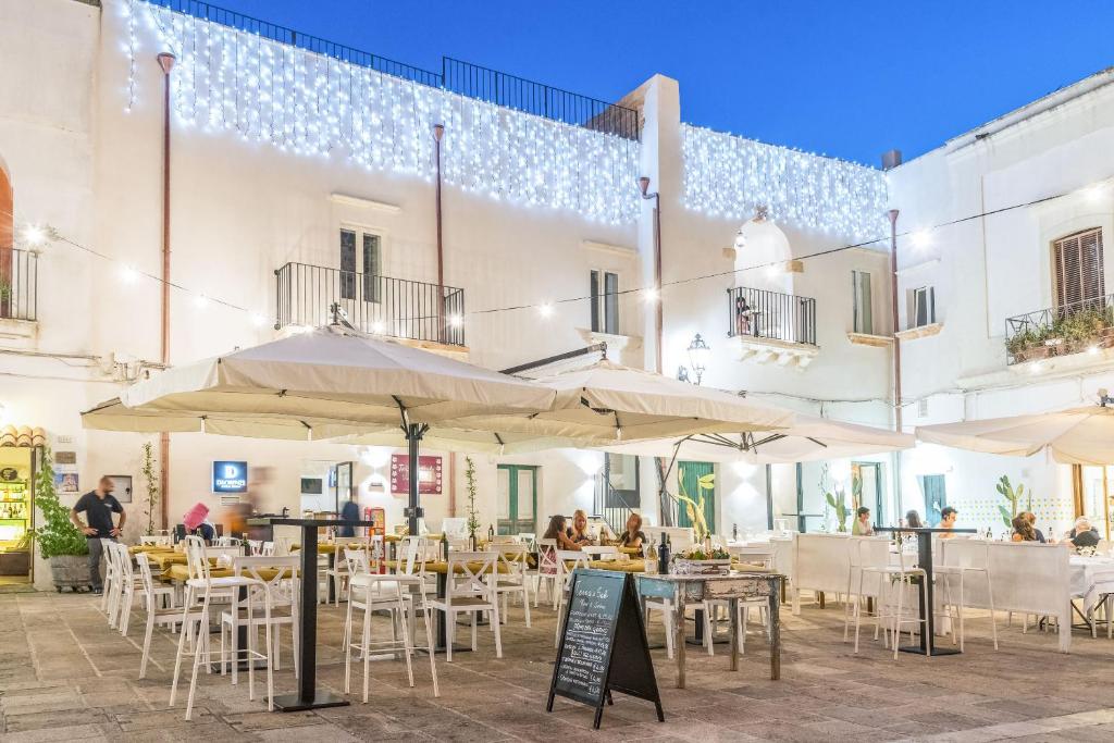 un patio con tavoli e ombrelloni di fronte a un edificio di Di Lorenzi Albergo Diffuso a Felline