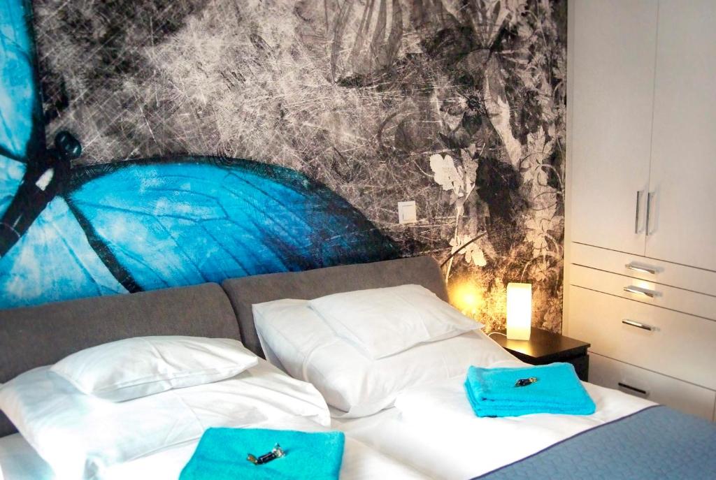 a bedroom with a bed with two blue bags on it at Victoria Apartman in Kecskemét