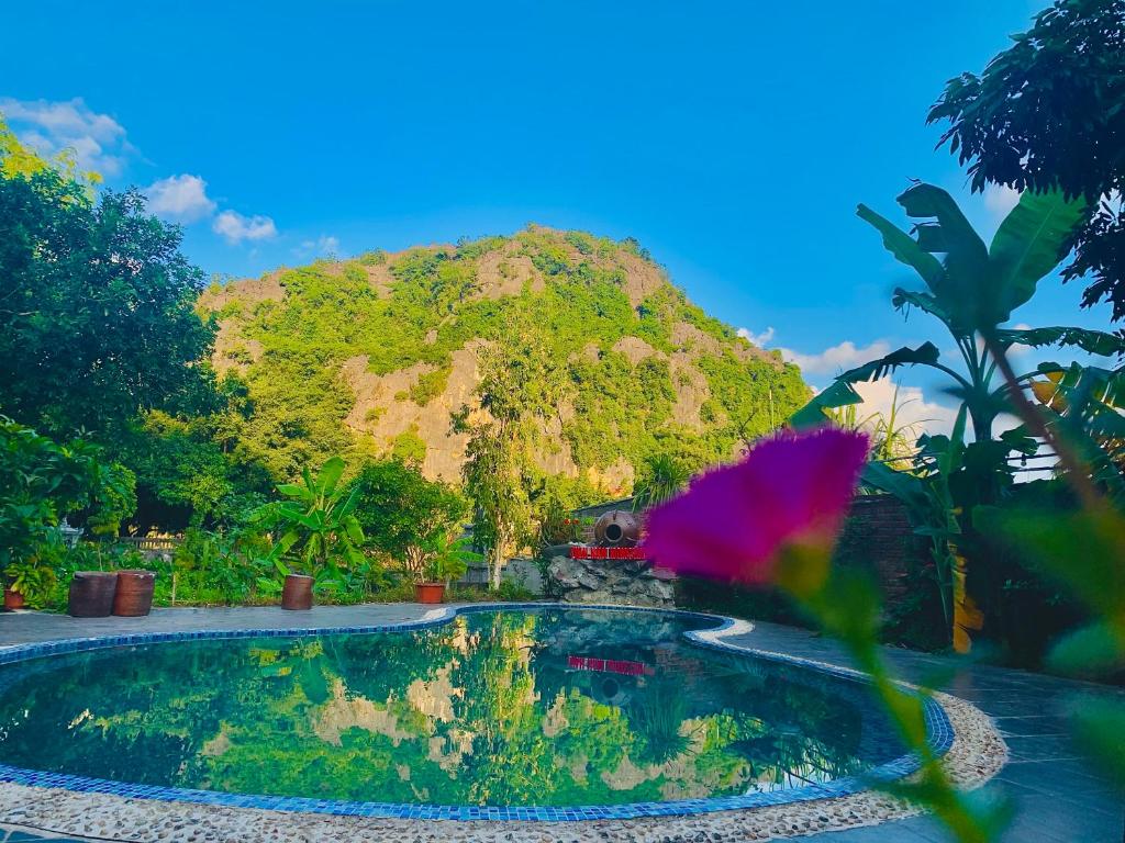 una piscina con una montagna sullo sfondo di Tuan Nam Homestay a Ninh Binh