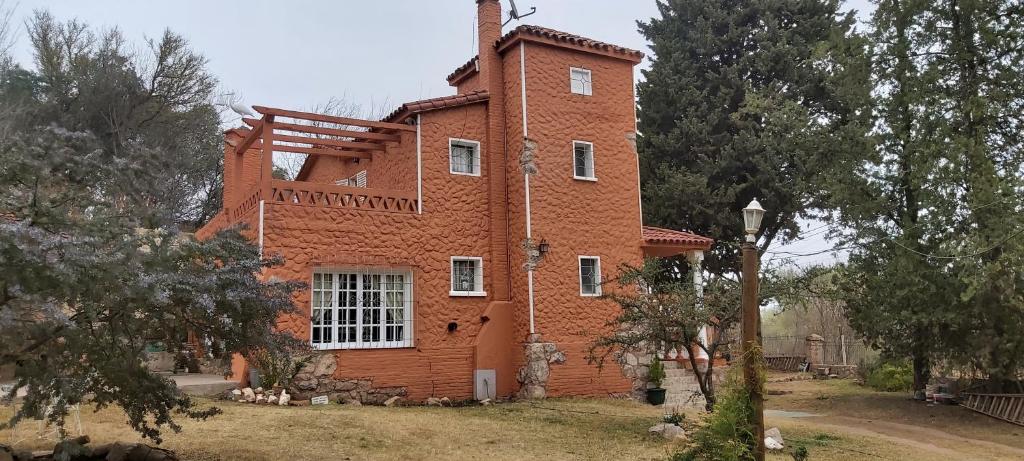a brick house with a tower on top of it at Cabañas EL CASTILLO in Villa del Dique