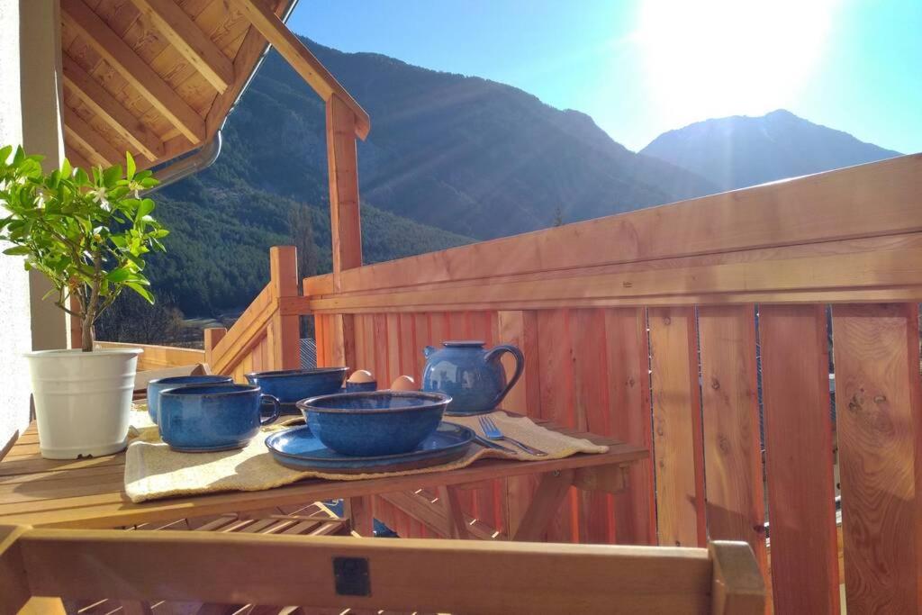 einen Tisch mit blauen Schüsseln und Platten auf einem Zaun in der Unterkunft Le Grand PIerron Clarée Valley cosy apartment in mountain, 6p in Val-des-Prés
