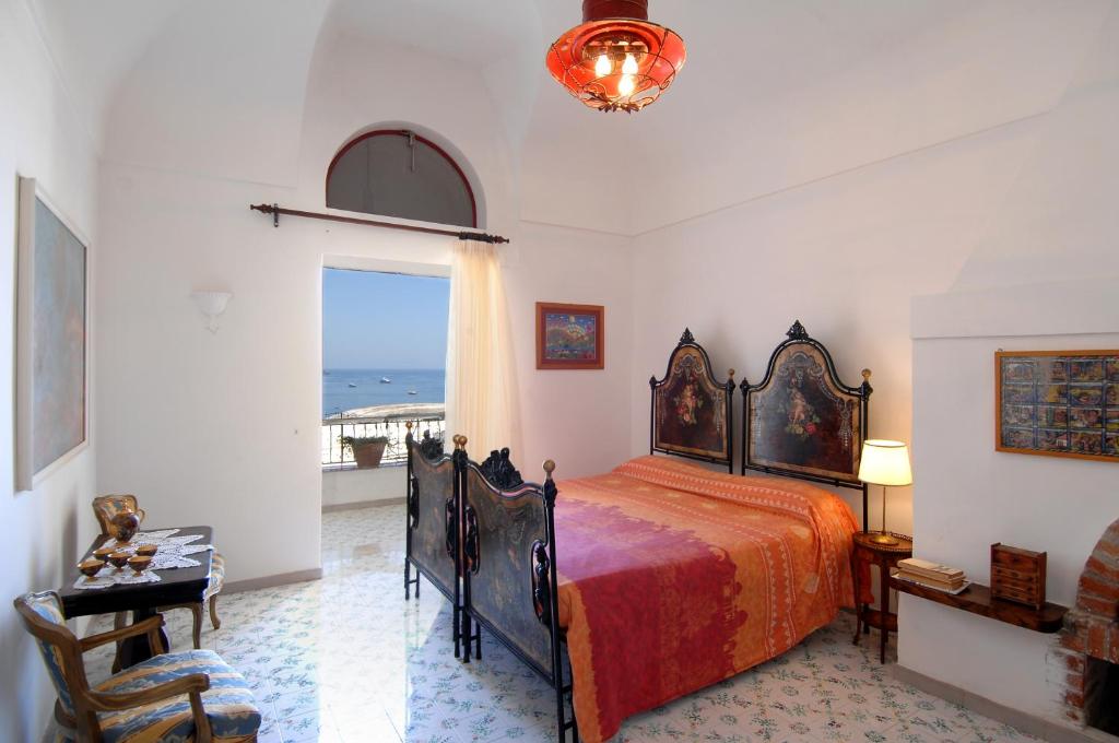 1 dormitorio con cama y vistas al océano en Casa Bouganville, en Positano