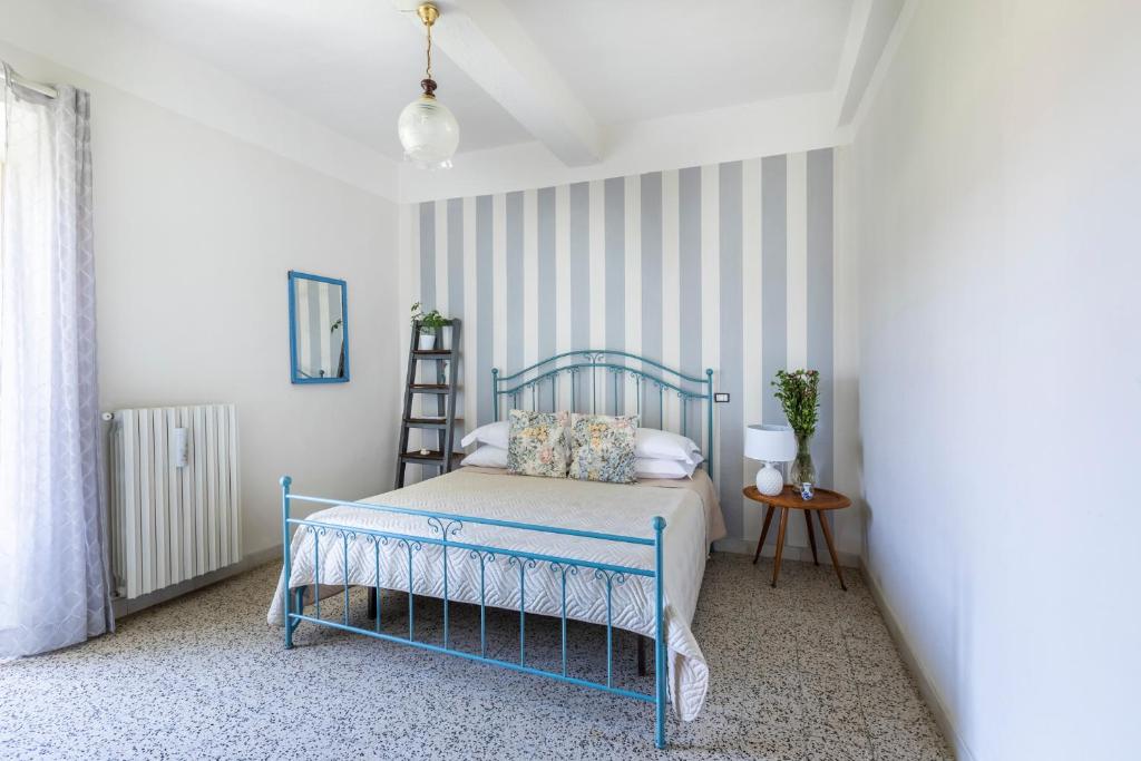 a bedroom with a blue bed and striped walls at B&b San Rocco in Celleno