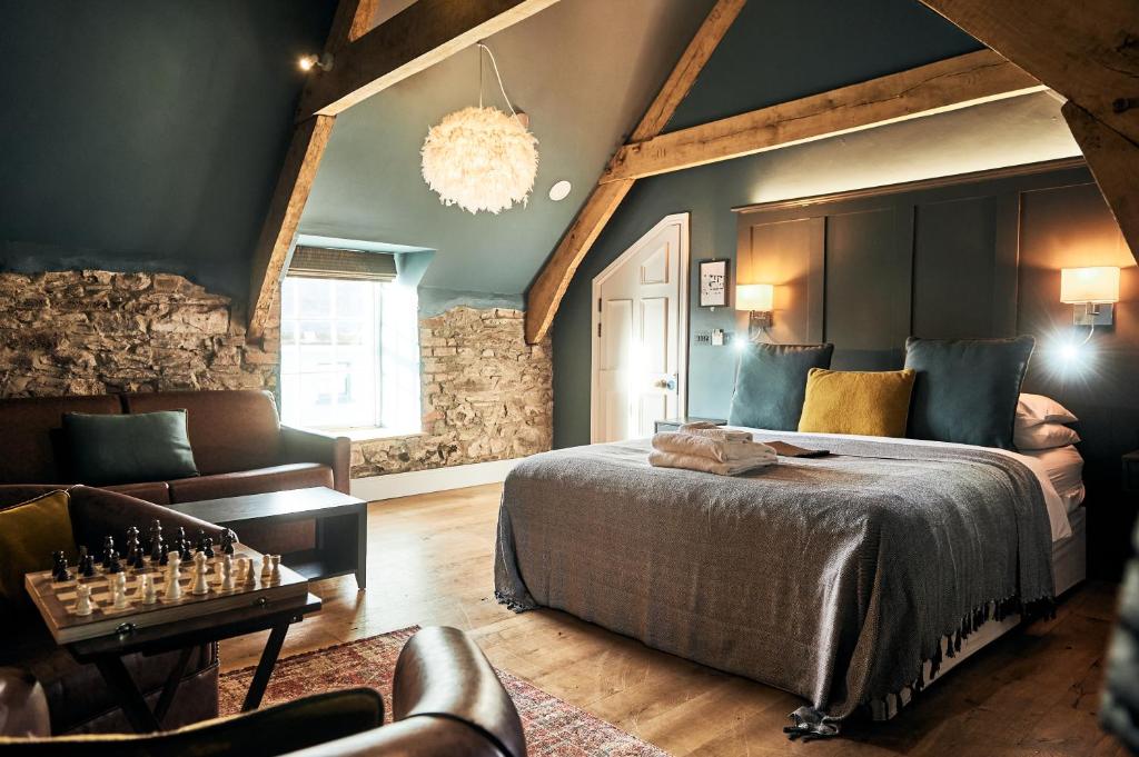 1 dormitorio con 1 cama grande y 1 sofá en The Brown's Hotel, en Laugharne