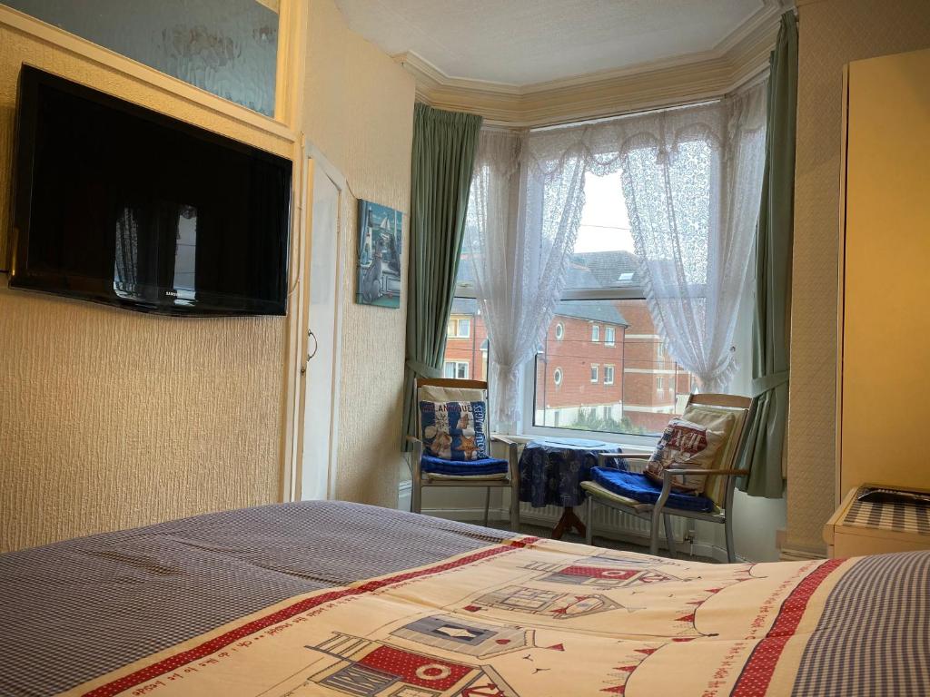 um quarto com uma cama grande e uma janela em Cumbria Guest House em Lytham St Annes