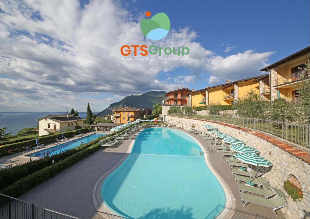 a hotel with a swimming pool and lounge chairs at Residence Besass, GTSGroup in Tignale