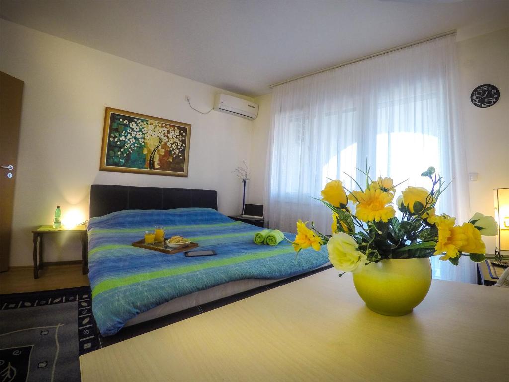 a bedroom with a bed and a vase of flowers on a table at Kristal in Banja Koviljača