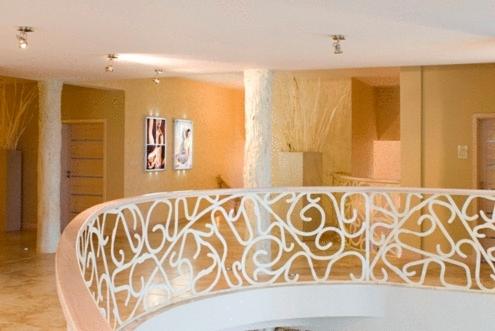 Curved staircase with ornate railing in a spacious, well-lit interior.