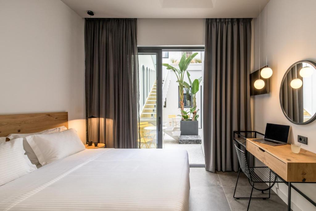 a bedroom with a bed and a desk with a laptop at Domus Ariadne in Heraklio Town
