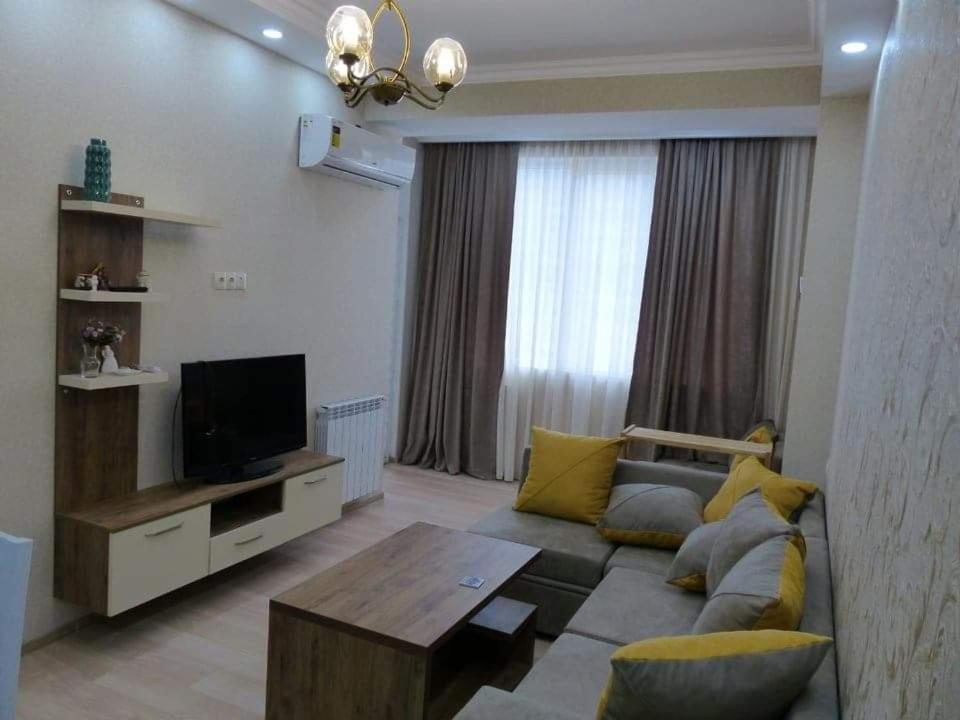 sala de estar con sofá y TV en The Apartment for Comfortable Vacations in Tbilisi., en Tiflis