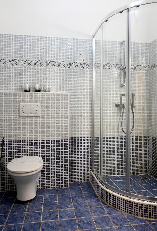 a bathroom with a toilet and a glass shower at Hotel Bouček in Kroměříž